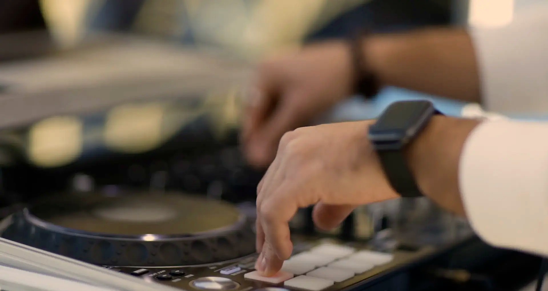 Close-up of a DJ's hands working a controller during a live set