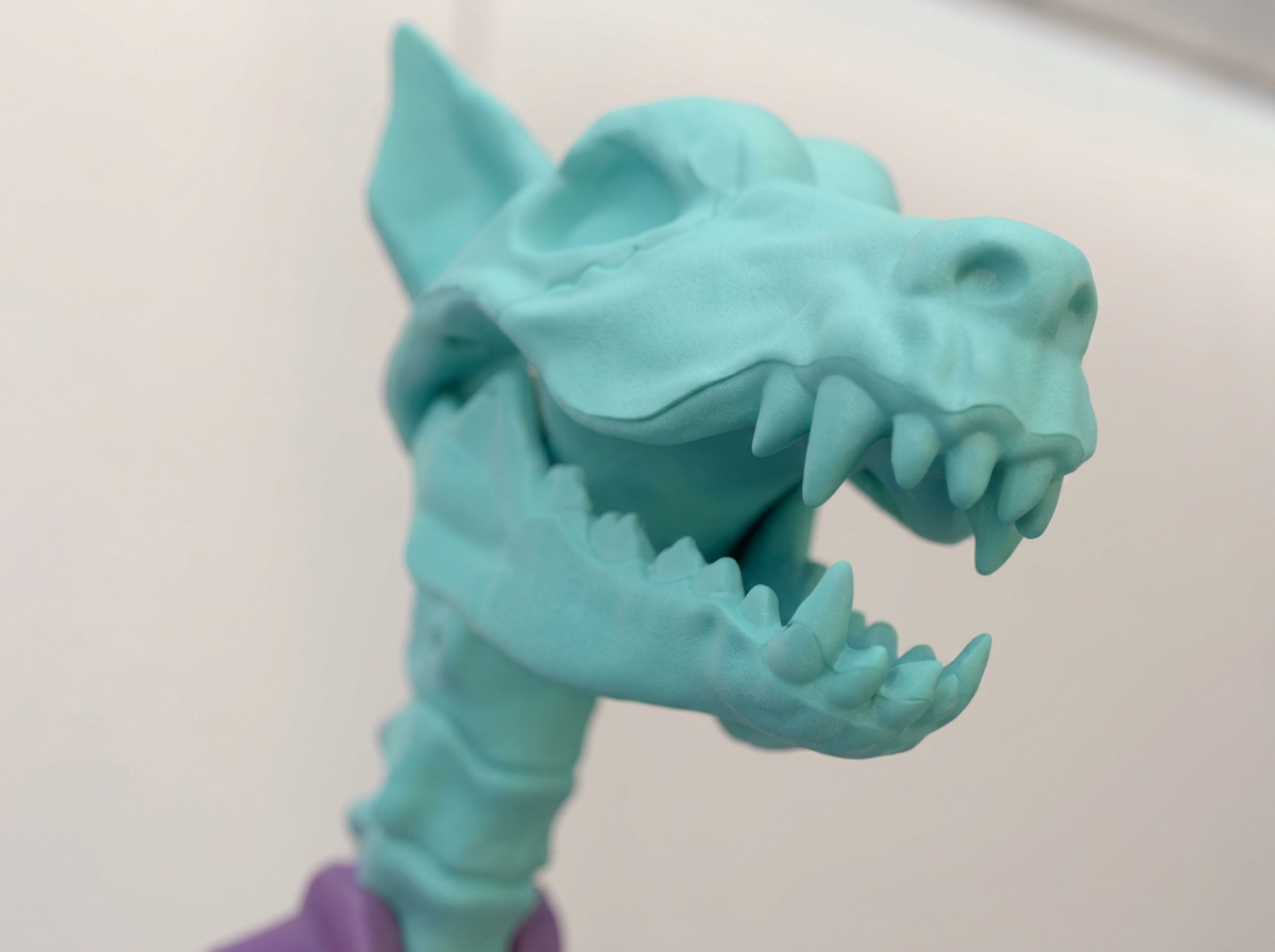 Teal resin sculpture of a wolf head with bared teeth