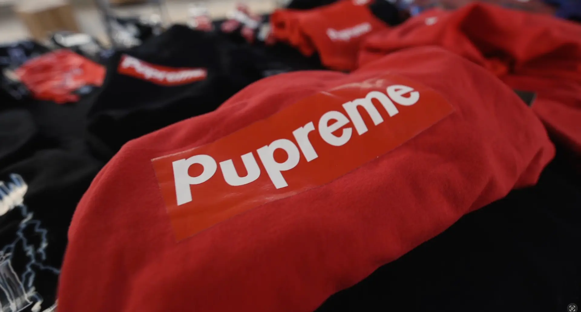 Stacks of red and black Pupreme box-logo sweatshirts