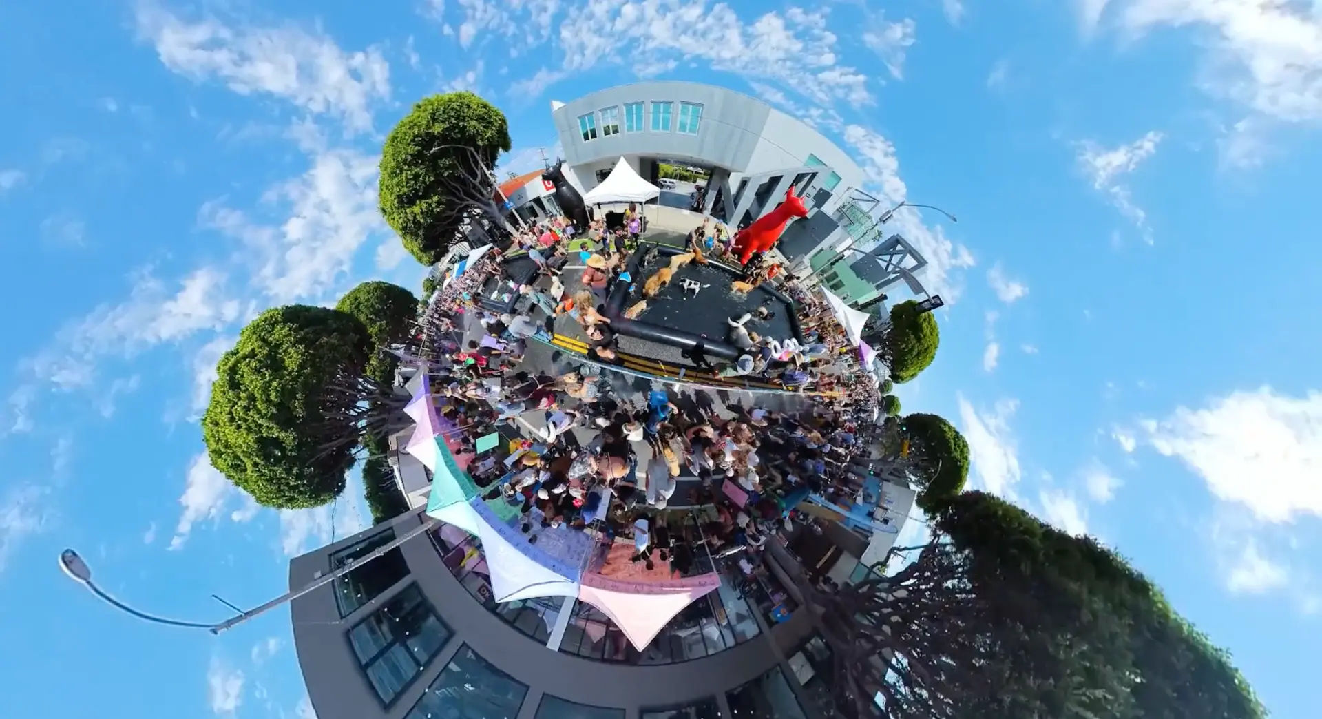 Tiny-planet view of the Art DOGL street festival crowd under blue sky